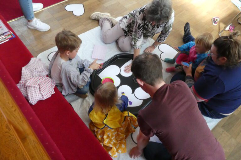 Adults and children decorating cut out large heart shapes