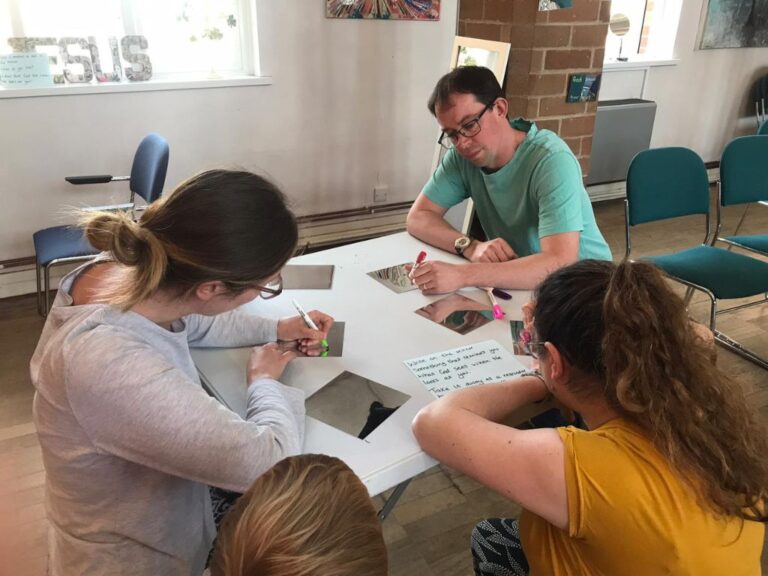 Adults and children writing on mirrored card