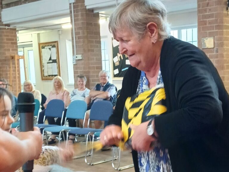 A senior and a child try to open a package