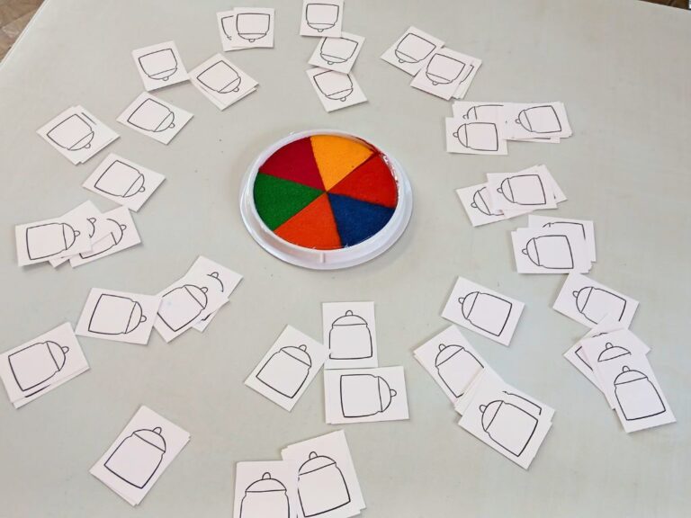 A multi-coloured ink pad on a table, surrounded by small images of flour jars with lids.