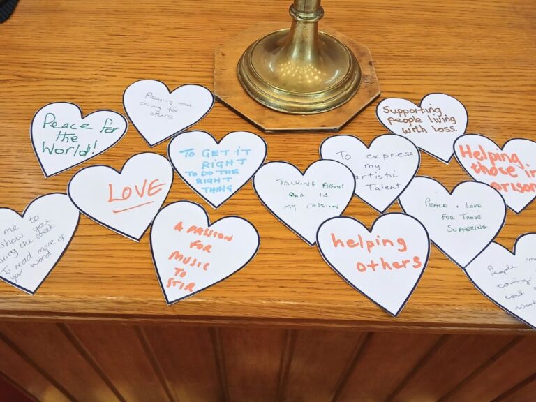 Paper hearts on a table, with writing on about people's passion for Jesus.
