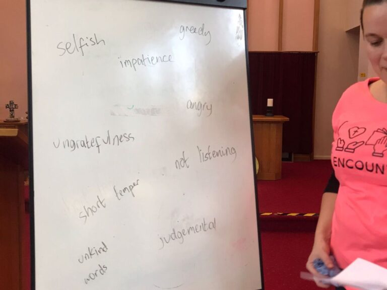 A whiteboard on which has been written things we are confessing to God (selfish, impatience, greedy, ungratefulness, short temper, unkind words, judgemental, not listening)