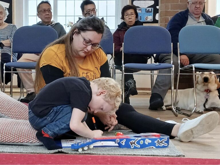 A small boy and a woman taking part in bingo.
