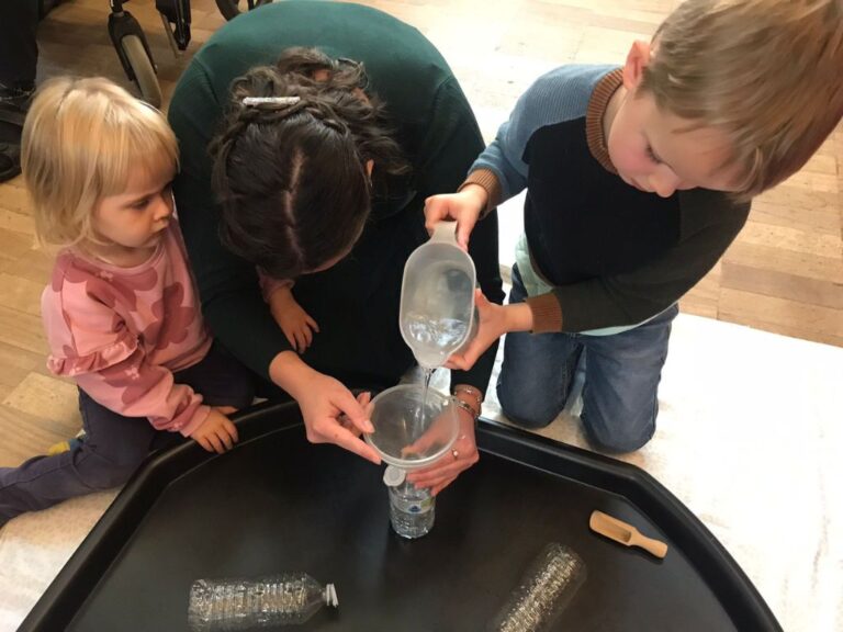 A child pouring water into a plastic bottle.