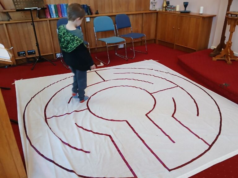 A young boy working a labyrinth.