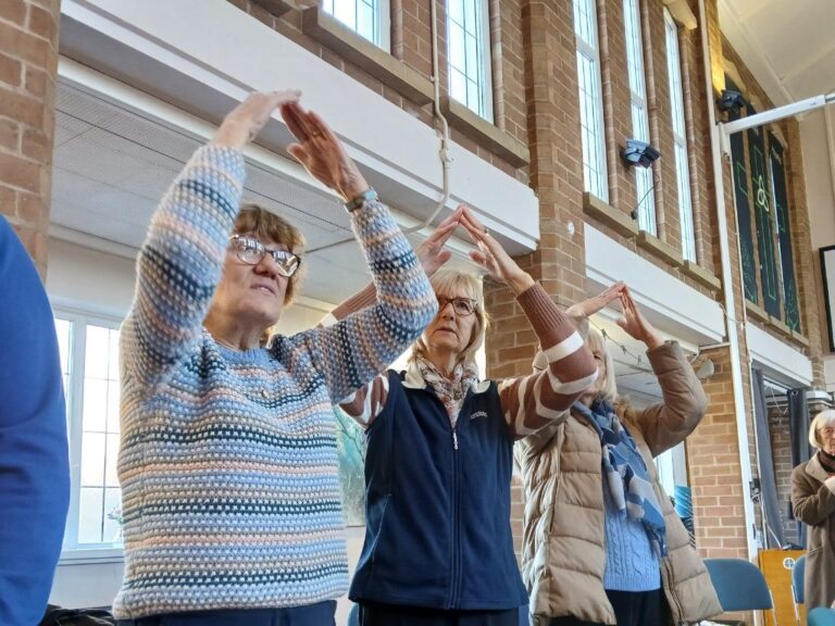Three ladies doing the actions to