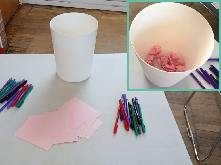 A bin on a table with paper and pens. In an inset image, screwed up pieces of paper can be seen in the bin.