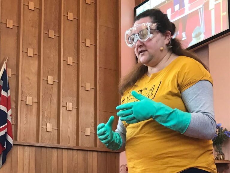 Woman wearing safety goggles and rubber gloves.