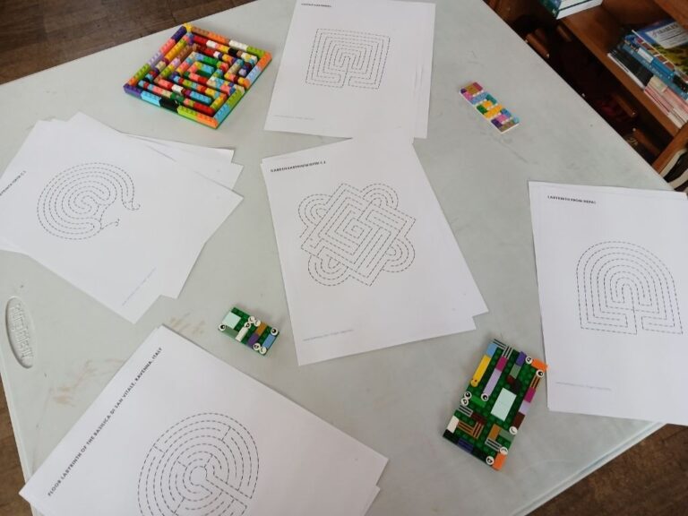 A table laid out with paper and lego labyrinths.