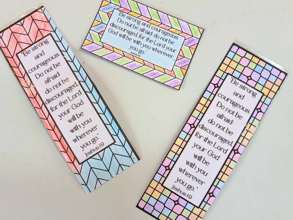 Coloured in and laminated bookmarks and wallet-sized cards with the words of Joshua 1:9.